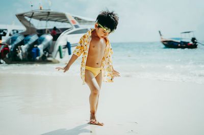 Full length of young woman standing on beach