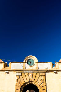 Low angle view of clock tower against clear blue sky