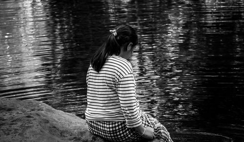 Rear view of woman standing in lake