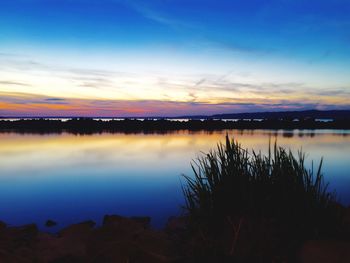 Scenic view of lake against sky at sunset