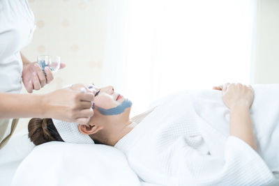 Midsection of woman resting on bed