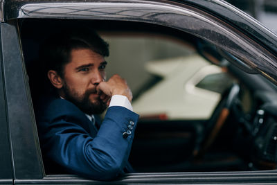 Portrait of young man sitting in car