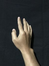 Close-up of human hand against black background