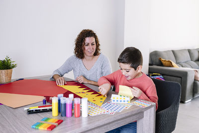 Mother and son making crafts at home with cardstocks and stickers