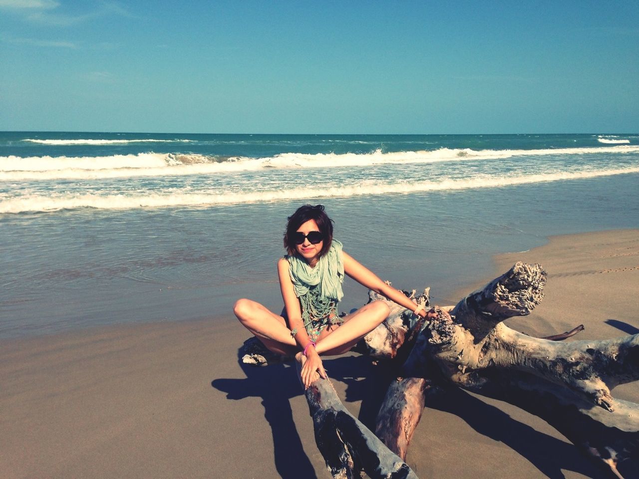 sea, beach, horizon over water, young adult, water, lifestyles, leisure activity, shore, person, young women, sand, clear sky, vacations, looking at camera, sunglasses, portrait, casual clothing, sitting