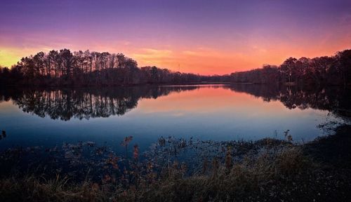 Scenic view of lake against sky at sunset