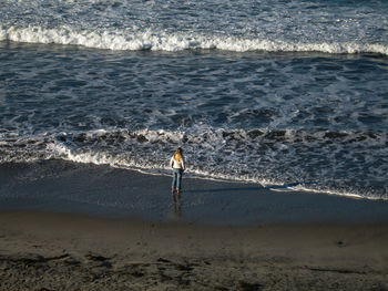 Man standing on beach by sea