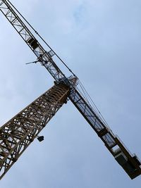 Low angle view of crane against sky