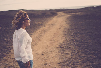 Woman standing on dirt road
