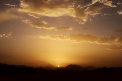 Scenic view of silhouette mountains against sky during sunset