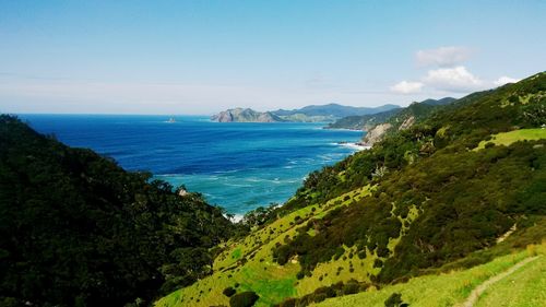 Scenic view of sea and mountains against blue sky