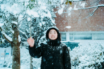 Portrait of young woman standing on snow