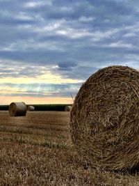 Hay bales on field against sky