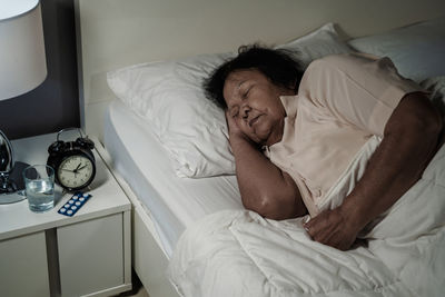 Senior woman sleeping on bed at home