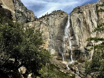 Low angle view of waterfall on rocks