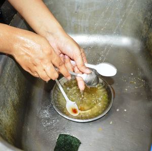 High angle view of person washing utensils in water 