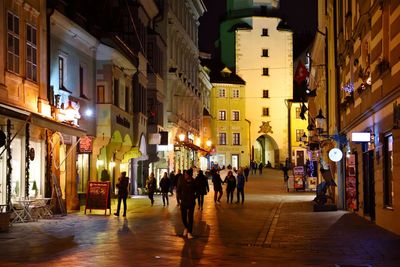 People walking in illuminated city at night