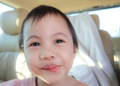 Close-up portrait of cute baby girl sitting in car