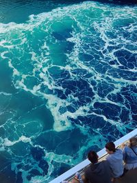 High angle view of people standing by railing over sea