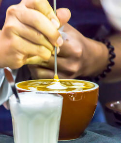 Close-up of hand pouring drink in glass