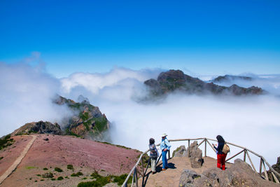 People on mountain against sky