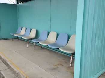 Empty chairs against wall in building