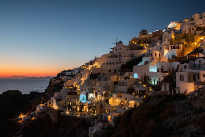 Town by sea against sky at sunset