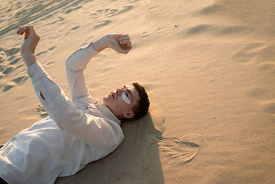 Man gesturing while lying on beach
