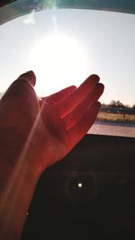 Close-up of hand against sky