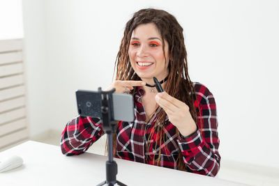 Portrait of smiling woman sitting on table