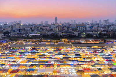 Aerial view of illuminated buildings against sky during sunset