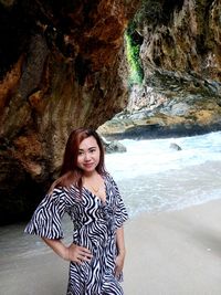 Portrait of young woman standing on rock