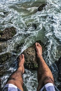 Low section of man standing on beach