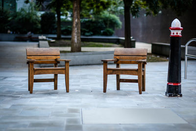 Empty table and chairs against trees