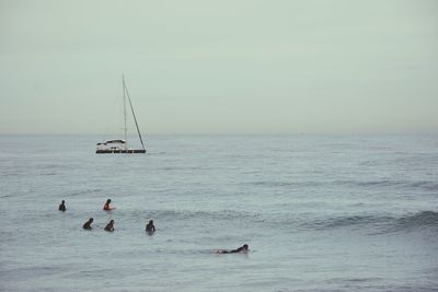 People in sea against sky