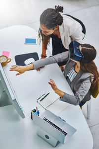 High angle view of businesswoman using virtual reality simulator at office