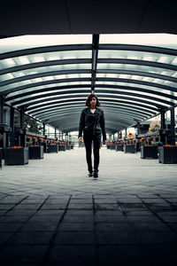 Full length portrait of young man standing on railroad station