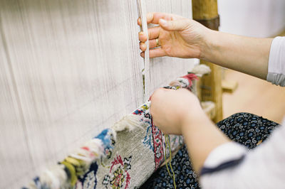 Close-up of woman working on loom