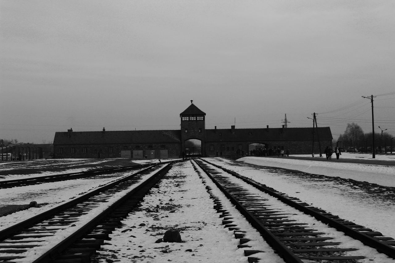 RAILROAD TRACKS BY SNOW COVERED LANDSCAPE