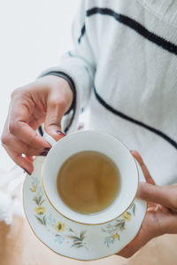 Midsection of woman holding coffee cup