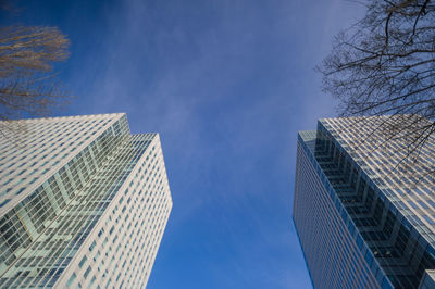 Low angle view of skyscrapers against blue sky