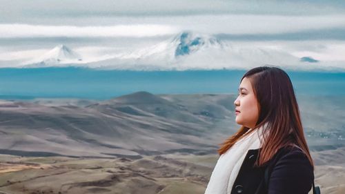 Woman looking at mountains against sky