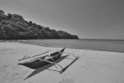 Monochrome beach landscape with one small boat in an isolated island