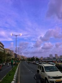 Cars on street in city against sky