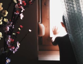 Boy looking through window