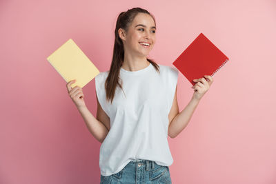 Portrait of smiling woman standing against red background