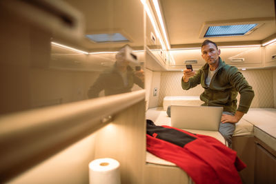Man holding remote control sitting in motor home