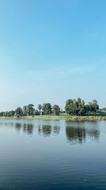 Scenic view of lake against clear blue sky