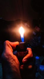 Close-up of hand holding burning candle