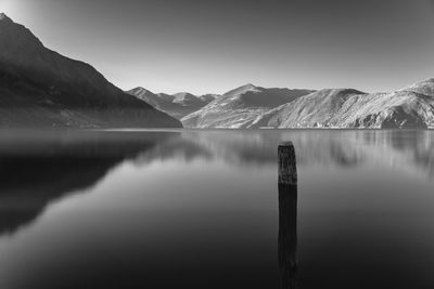 Scenic view of lake by mountains against clear sky